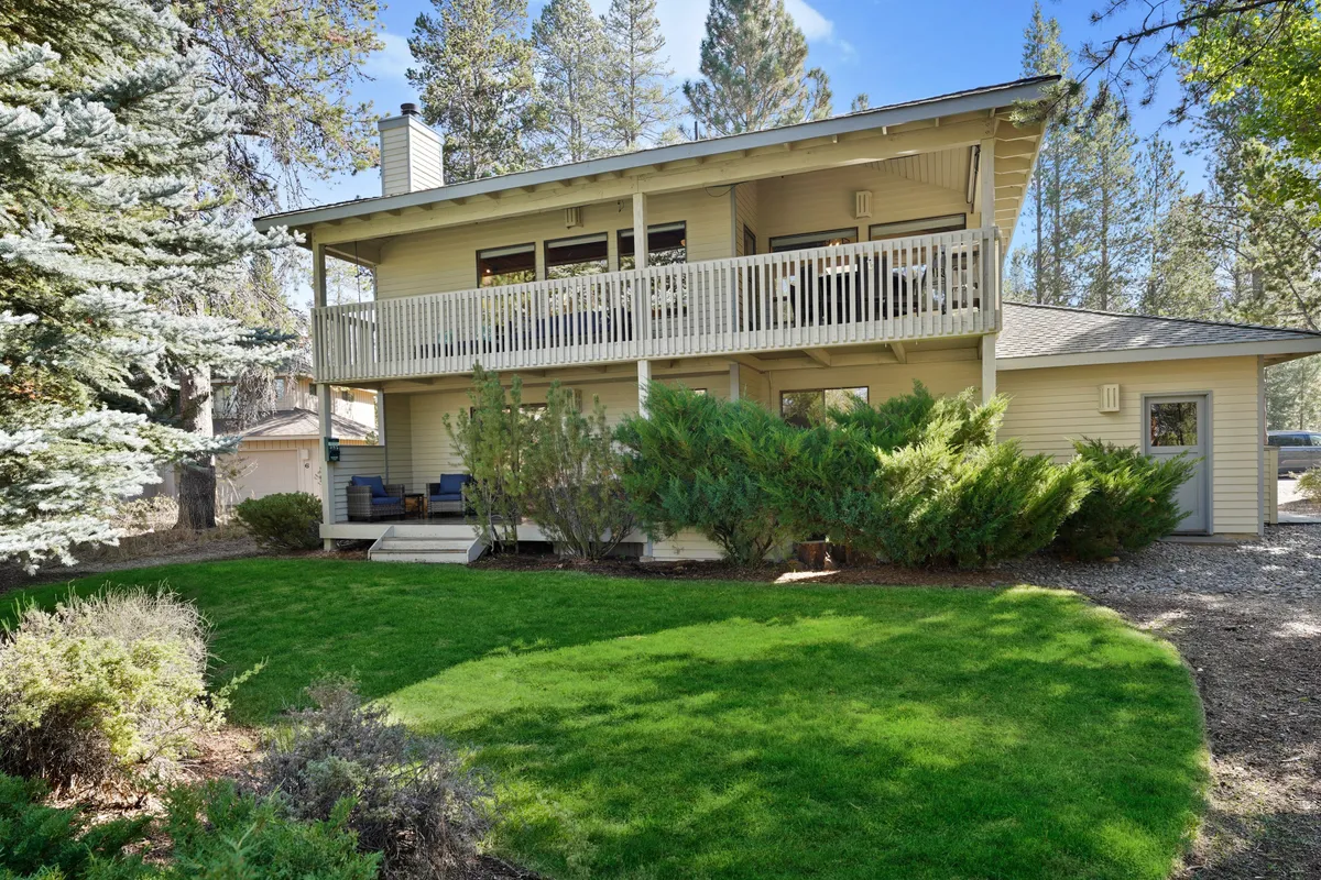 A peaceful balcony or upper deck overlooking a green lawn and framed by tall trees, offering serene views of the surrounding landscape. This space is perfect for morning coffee, sunset watching, or simply taking in the sights and sounds of nature.
